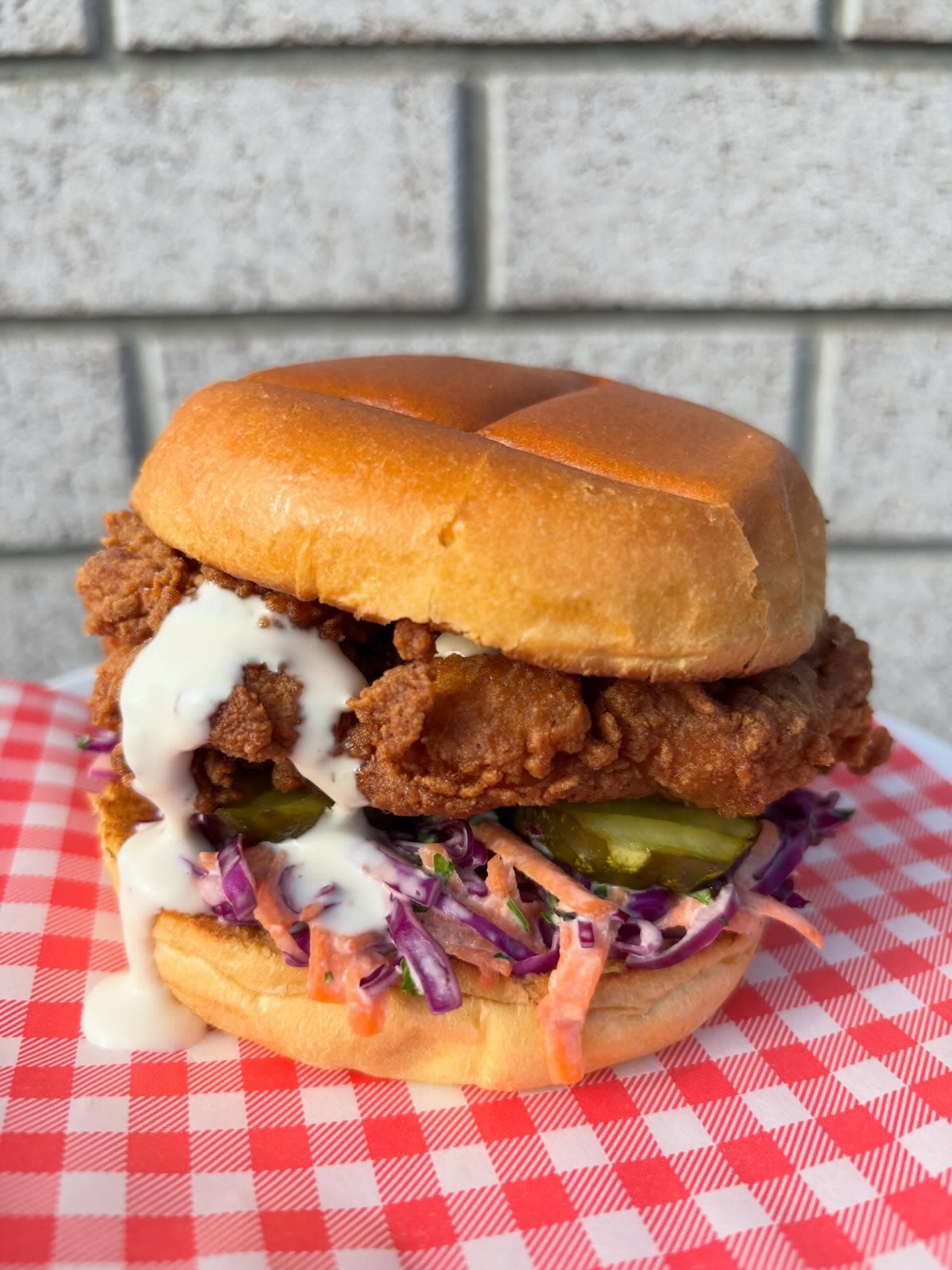 Burchie's fried chicken sandwich with slaw, pickles, and sauce